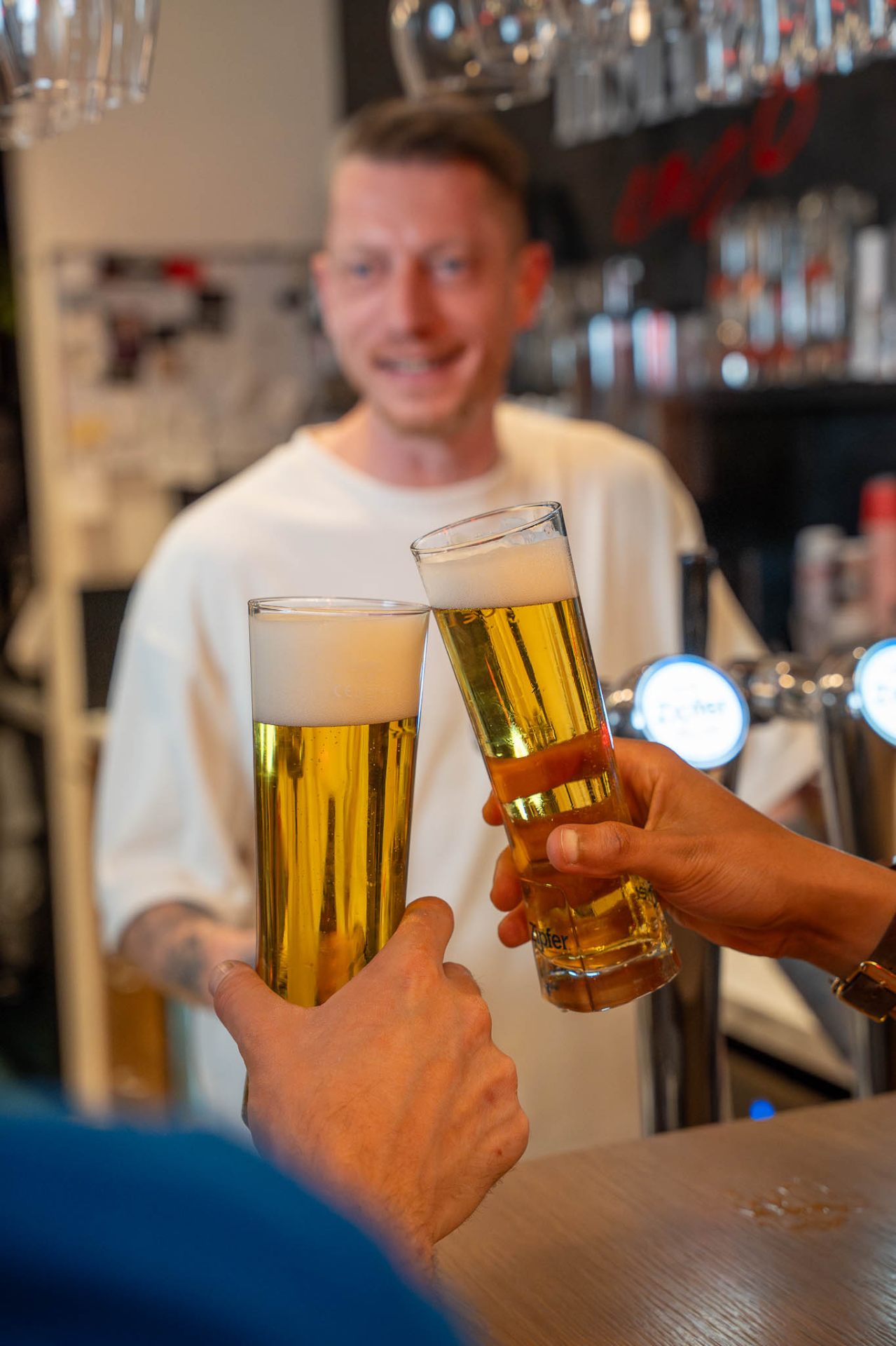 Anstoßen mit Bier an der Bar
